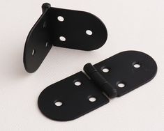 pair of black metal door hinges with holes on each side for easy access