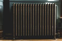 a radiator in a room with wood flooring and dark blue paint on the walls