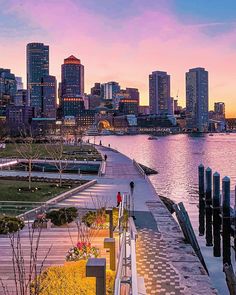 the city skyline is lit up at sunset