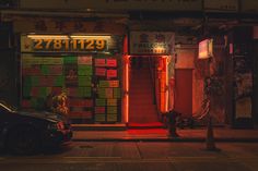 a car parked in front of a building with neon signs on the side of it