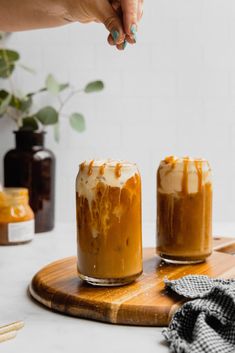 two jars filled with food sitting on top of a wooden cutting board