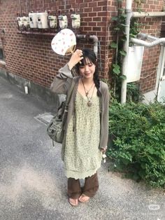 a woman standing in front of a brick building holding a frisbee over her head