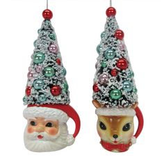 two christmas ornaments with santa claus and reindeer hats on them, one is holding a coffee mug