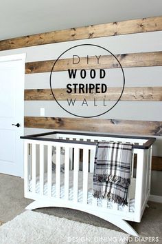 a white crib in front of a wooden wall with the words diy wood striped wall on it