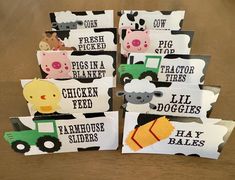 several farm animals and tractor themed tags on a wooden table with text that reads, pig, chicken, sheep, hay bales