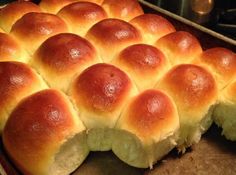 a pan filled with rolls sitting on top of a wooden table next to an oven