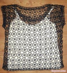 a black and white crochet top sitting on top of a wooden floor