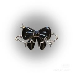 a black bow brooch sitting on top of a white surface