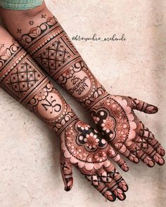 two hands with henna tattoos on them