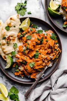 two plates filled with chicken tikka and tortillas on top of a table