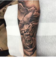 a black and white photo of a bird with roses on it's arm,