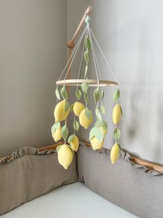 a baby crib mobile with lemons and leaves hanging from it's sides