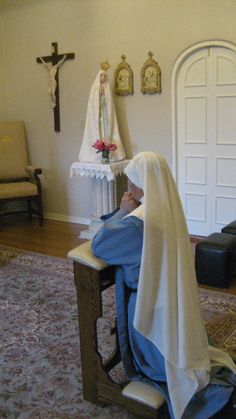 a nun sitting at a desk in front of a cross