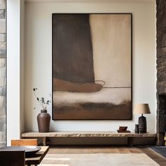 a living room with a large painting hanging on the wall next to a fire place