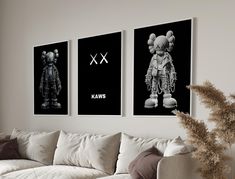 three black and white pictures hang on the wall above a couch