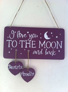 i love you to the moon and back sign with two hearts hanging from it's hooks