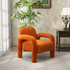 an orange chair sitting in front of a potted plant