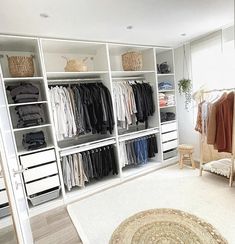 an organized closet with white shelving and lots of clothes