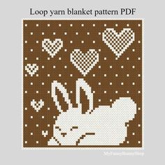 a cross stitch pattern with an image of a white rabbit and hearts on brown background