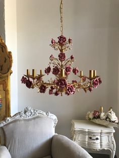 a chandelier hanging from the ceiling in a room with white walls and furniture