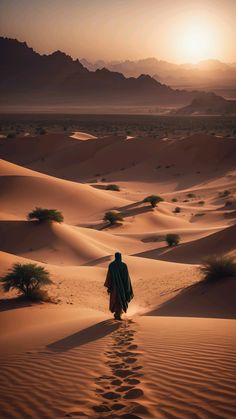 a person walking in the desert at sunset