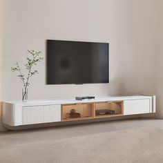 a flat screen tv mounted to the side of a white entertainment center in a living room