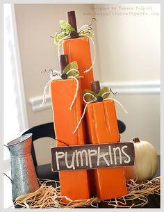 pumpkins are stacked on top of each other in front of a sign that says pumpkins