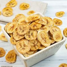 a bowl filled with sliced bananas sitting on top of a white table next to some napkins