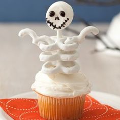 a cupcake with white frosting and a skeleton on top