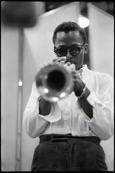 a man playing a trumpet in front of a mirror