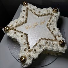 a cake decorated with white frosting and gold decorations