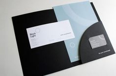 a black and blue folder with a white business card on the front, next to it