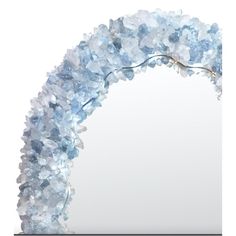 an arch made out of blue flowers on a white background with a mirror in the middle