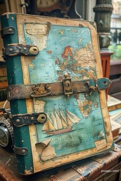 an old suitcase sitting on top of a table with a world map on the cover