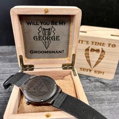 a watch in a wooden box with an engraved message on the front and back side