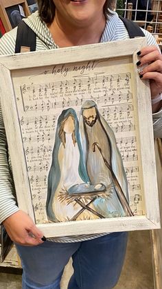 a woman holding up a framed painting with two birds on it's back and music notes in the background