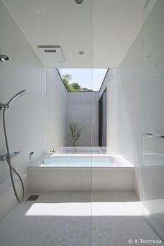 a bathroom with a bathtub, shower and sink in the middle of it's floor to ceiling glass walls