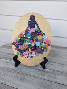 a wooden plaque with buttons in the shape of a woman's silhouette on it