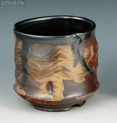 a brown and black vase sitting on top of a table