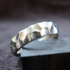 "Titanium Ring, Hand-carved rocky modeling, mountain stone texture ring. Each Titanium ring is handcrafted out of a solid piece of Grade 2 Titanium in an extremely time-consuming process to create a truly unique ring, this ring is 100% handmade forged from a single piece of titanium plate using traditional blacksmithing techniques of fire and hammer, due to the production method, each ring will be unique with hand-carved rocky modeling. Want this ring but are unsure of your size? Select the \" S Anodized Titanium, Textured Ring, Men's Wedding Ring, Stone Texture, Etsy Wedding Rings, Titanium Rings, Handcrafted Rings, Luxury Watches For Men, Jewelry Inspo