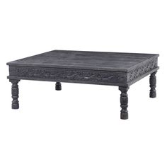 an old wooden coffee table with carvings on the top and bottom, sitting against a white background