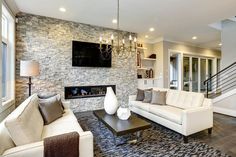 a living room filled with furniture and a flat screen tv mounted on the wall above a fireplace