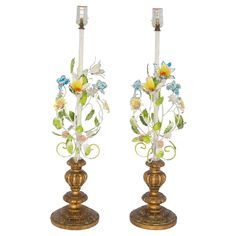 two metal candlesticks decorated with flowers and leaves