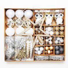 an open box filled with christmas ornaments and other items, including balls, candles, ornament