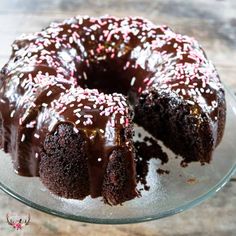 a bundt cake with chocolate frosting and sprinkles on a glass plate