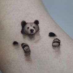 a bear's paw and foot prints are shown on the side of a woman's thigh