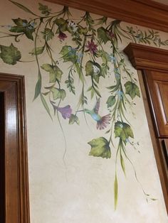 the wall is painted with flowers and leaves