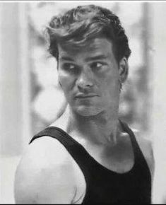 a black and white photo of a man in a tank top looking at the camera