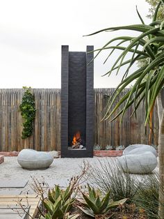 an outdoor fire pit surrounded by plants and rocks