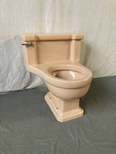 a toilet bowl with the lid up on a gray surface next to a white sheet